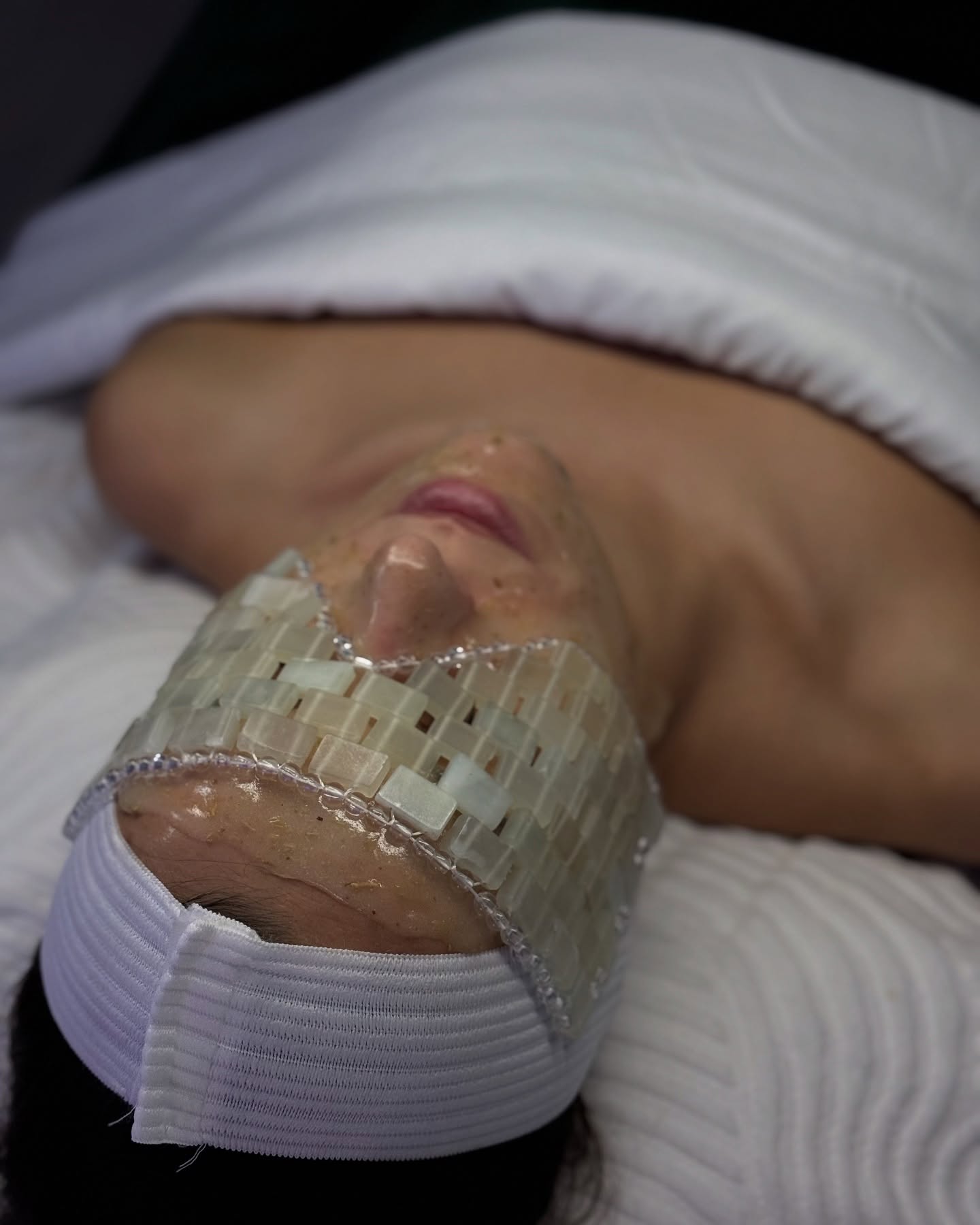 Person with eye mask and facial treatment at Skin Lounge Med Spa.