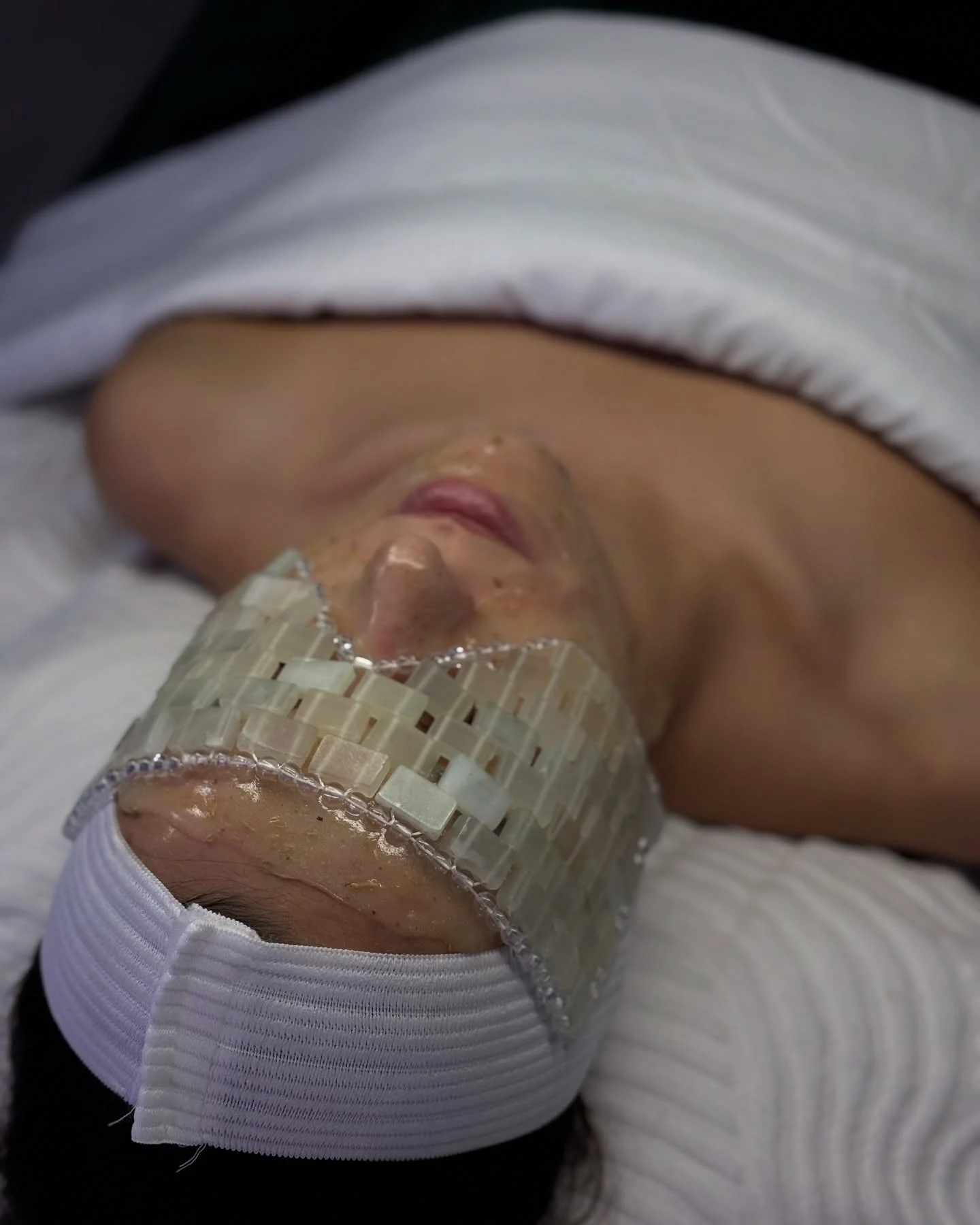 Person with eye mask and facial treatment at Skin Lounge Med Spa.