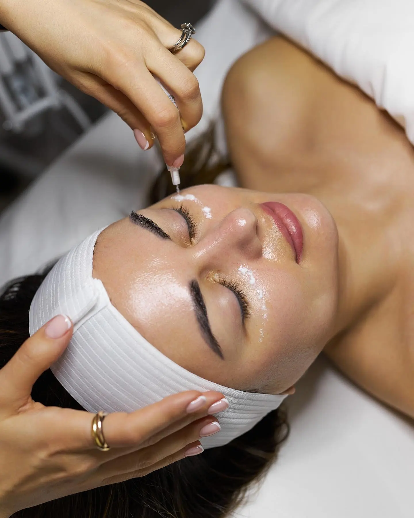 Woman receives facial treatment with a needle applicator.
