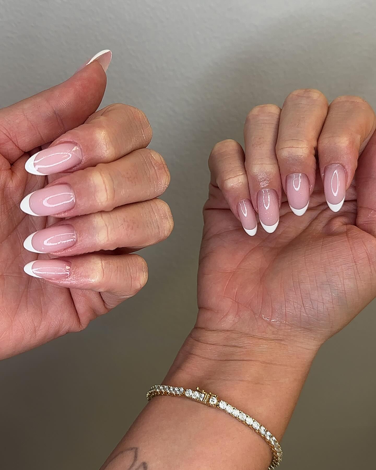 French manicure on oval-shaped nails with a diamond bracelet.