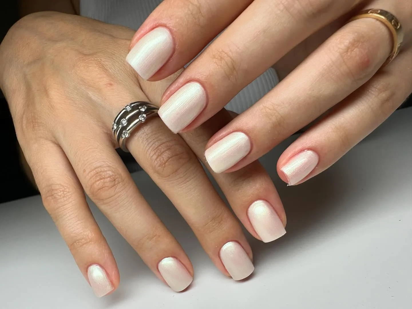 White pearl shimmer nails with rings.