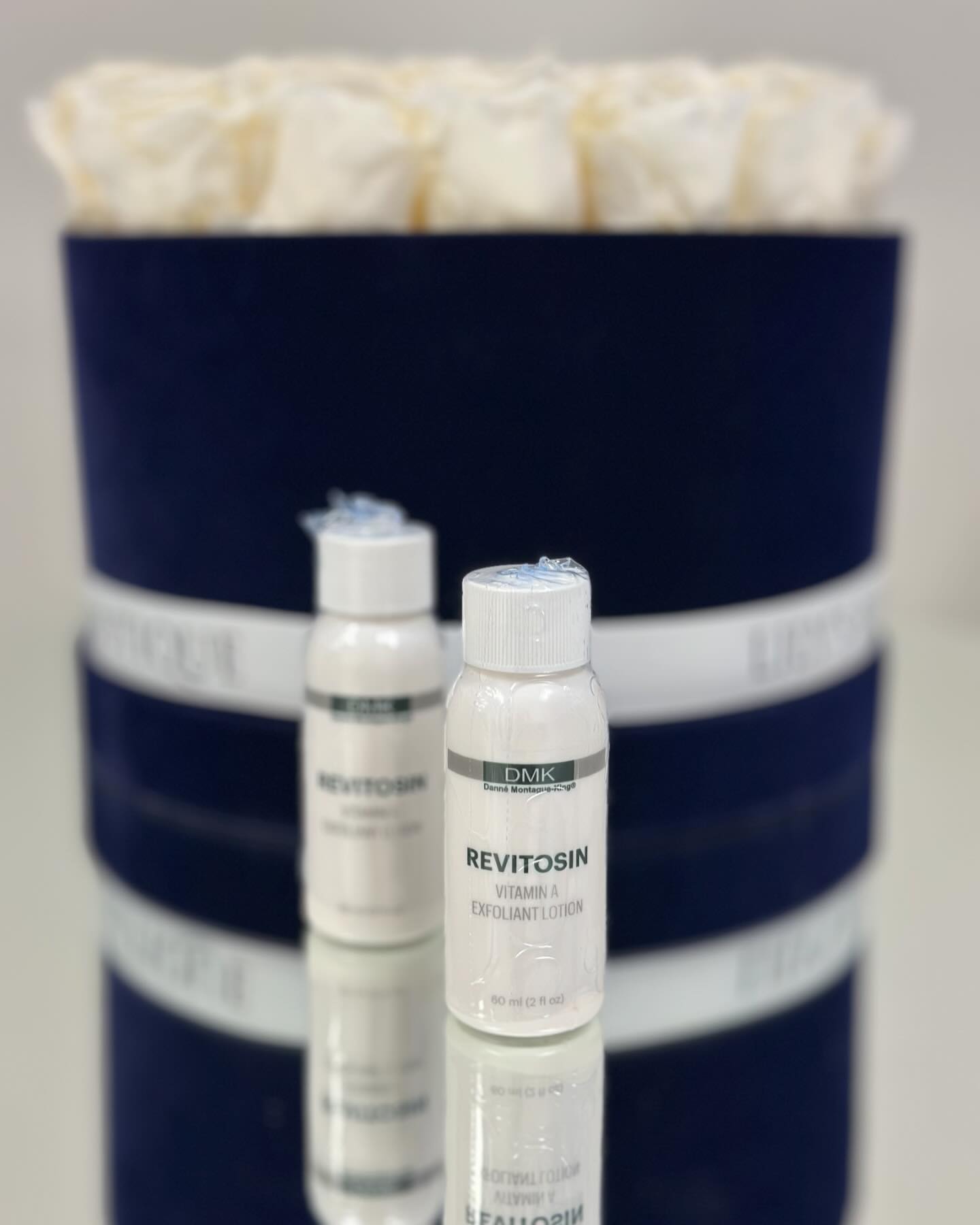nn DMK Revitosin Vitamin A Exfoliant Lotion in white bottles.