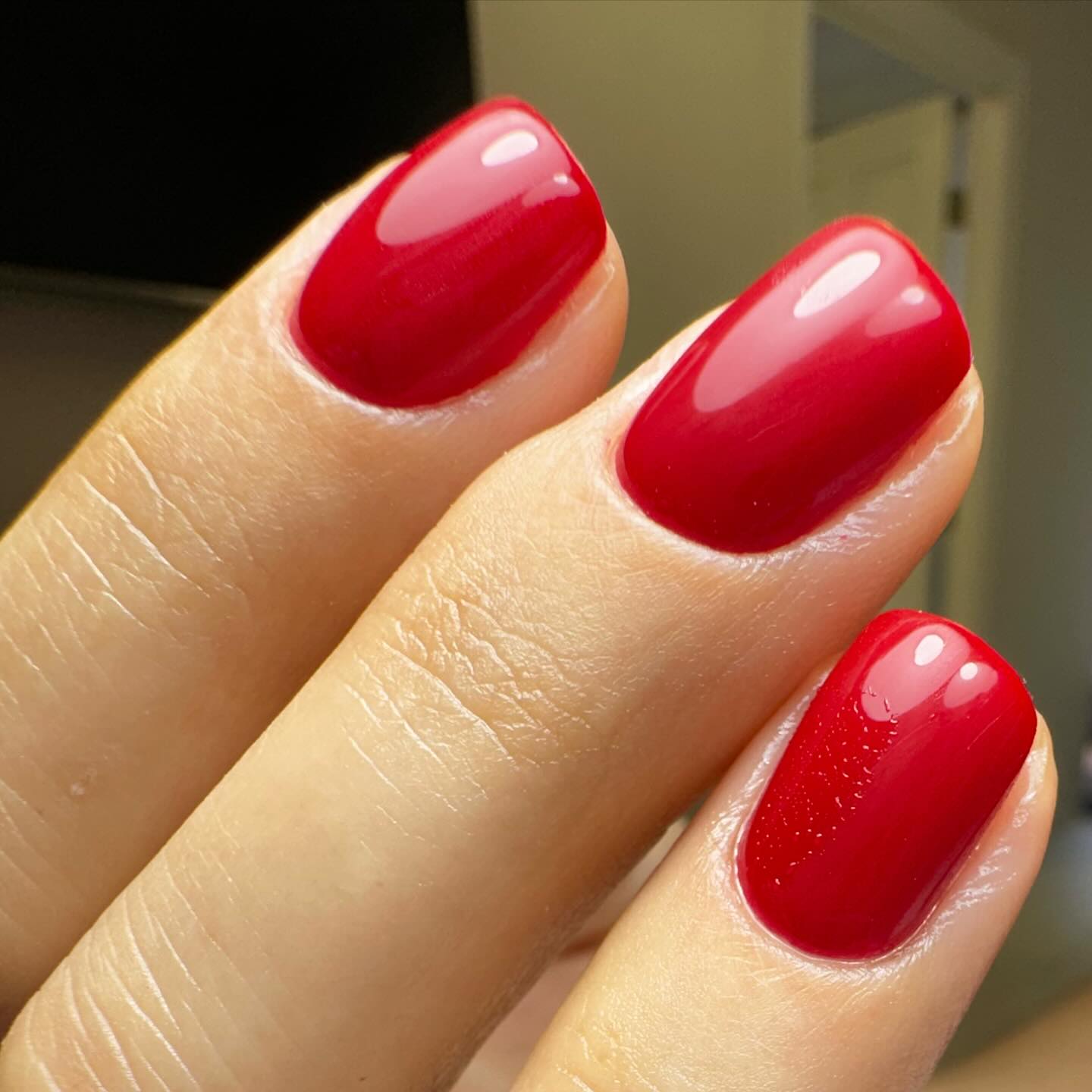 Red polished nails on fingers at Skin Lounge Med Spa.