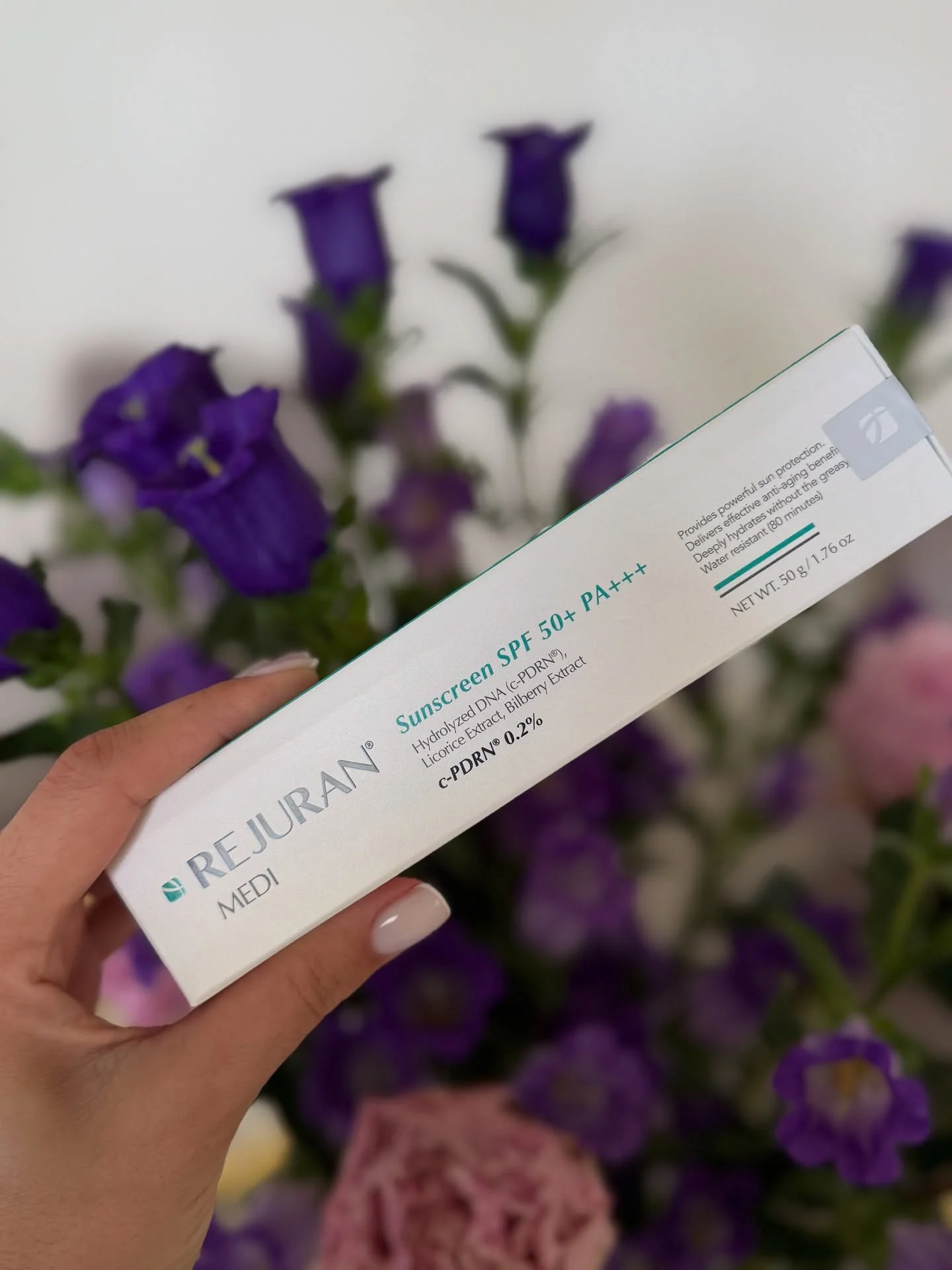 REJURAN sunscreen SPF 50+ PA+++ with flowers.